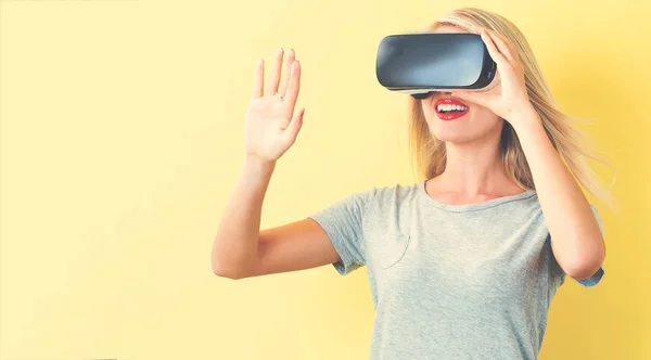 Mujer joven usando un auricular de realidad virtual —  Fotos de Stock