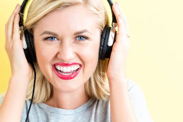 Mujer joven feliz con auriculares — Foto de Stock