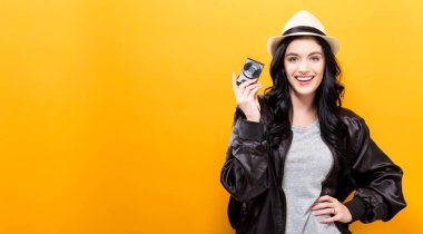  Kompakt bir fotoğraf makinesi tutan genç kadın 
