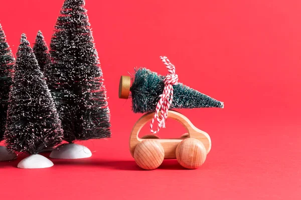 Μικρογραφία που μεταφέρουν ένα χριστουγεννιάτικο δέντρο ξύλινο αυτοκίνητο — Φωτογραφία Αρχείου