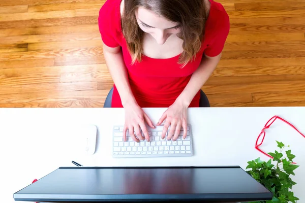 Νεαρή γυναίκα που εργάζεται σε έναν υπολογιστή — Φωτογραφία Αρχείου