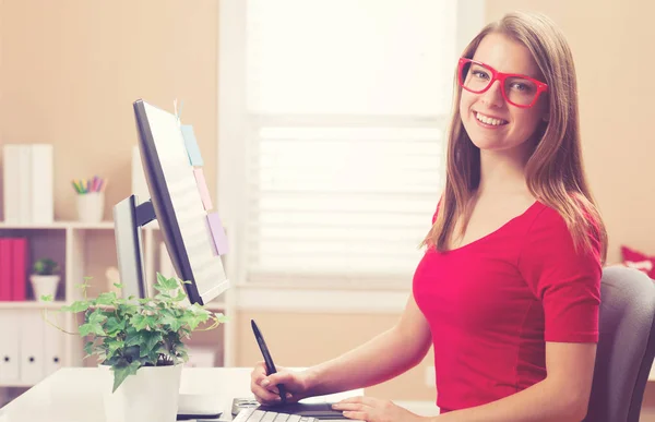 Jonge vrouw die werkt met een tablet-pen in haar kantoor aan huis — Stockfoto