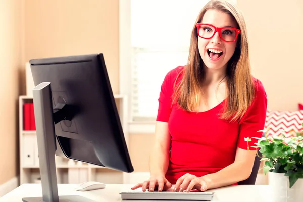Молода жінка працює на комп'ютері — стокове фото