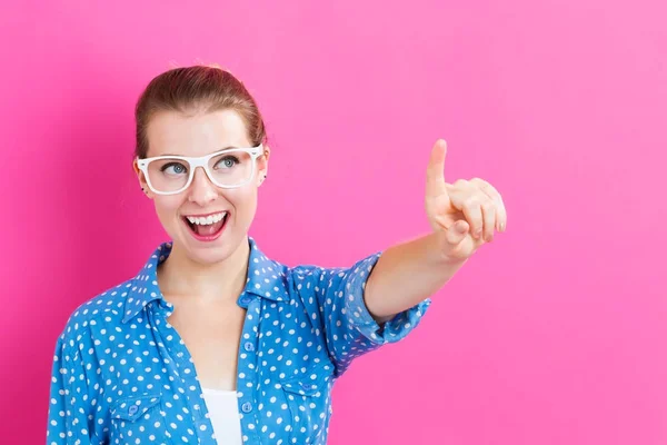 Gelukkig jonge woman wijzend iets — Stockfoto