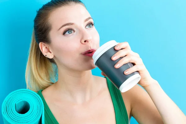 Mulher segurando xícara de café e tapete de ioga — Fotografia de Stock