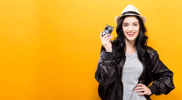 Молода жінка тримає компактну камеру — стокове фото
