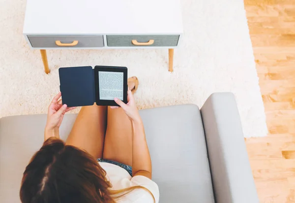 Молода жінка читає у своїй вітальні — стокове фото