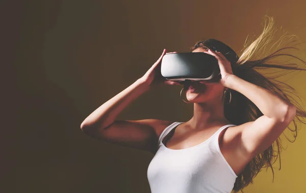 Jovem mulher usando fone de ouvido realidade virtual — Fotografia de Stock