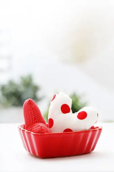 Cojines del corazón en un plato rojo del corazón — Foto de Stock