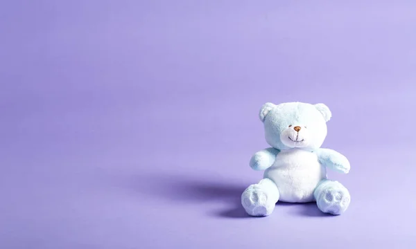 Bebé oso de peluche azul niño sobre un fondo púrpura — Foto de Stock