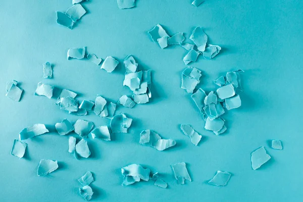 Trozos de papel esparcidos sobre azul — Foto de Stock