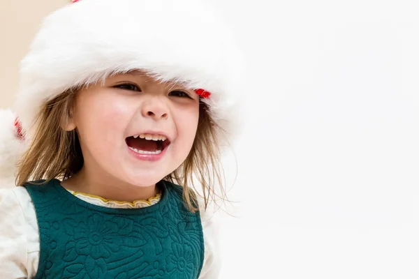 Gelukkig peuter meisje met een kerstmuts — Stockfoto