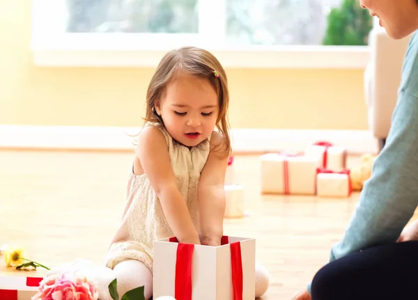 Gelukkig peuter meisje met een kerstcadeau — Stockfoto