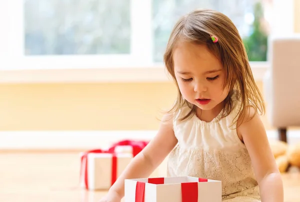 Liten flicka öppna en julklapp — Stockfoto