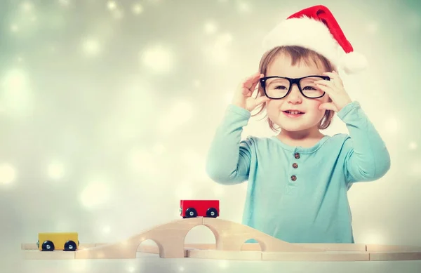 Kleuter meisje met kerstman hoed en bril — Stockfoto