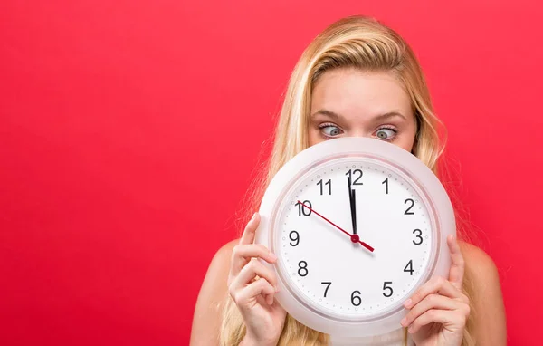 Mujer sosteniendo reloj mostrando casi 12 — Foto de Stock