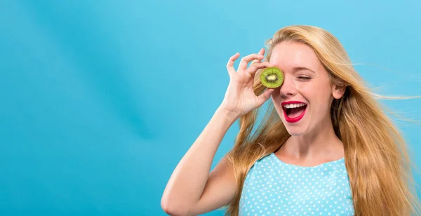 Glad ung kvinna anläggning Kiwi — Stockfoto