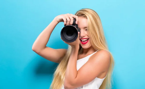 Jovem mulher comparando câmera profissional — Fotografia de Stock