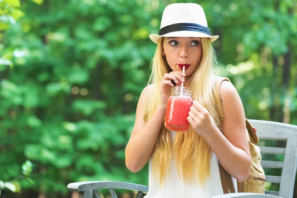 Junge Frau trinkt draußen einen Smoothie — Stockfoto