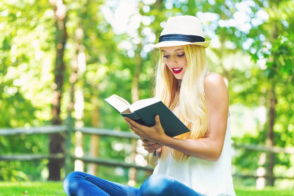 Jonge vrouw lezen van een boek buiten — Stockfoto