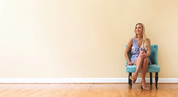 Młoda kobieta siedzi w dużym pokoju — Zdjęcie stockowe