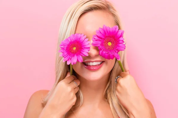 Mujer joven con garberas rosadas — Foto de Stock