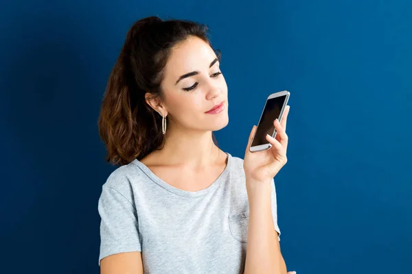 Ung kvinna som använder sin telefon — Stockfoto