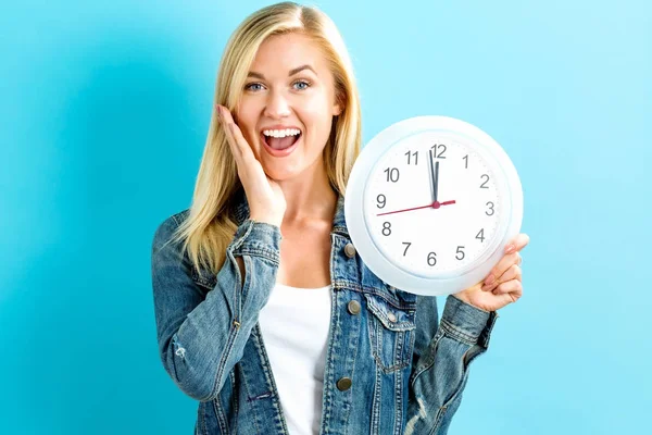 Mujer sosteniendo reloj mostrando casi 12 — Foto de Stock