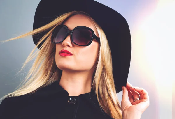 Beautiful blonde woman in a black coat — Stock Photo, Image