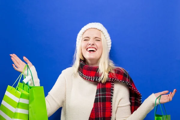 Glad ung kvinna som håller i shoppingväskor — Stockfoto