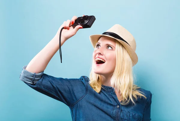 Mujer joven sosteniendo una cámara compacta — Foto de Stock