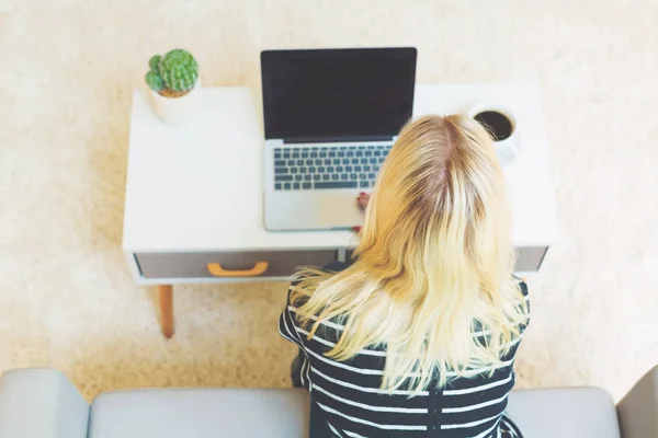 Junge Frau mit Laptop im Wohnzimmer — Stockfoto