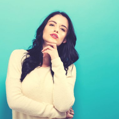 Sağlam bir arka plan üzerinde mutlu genç kadın