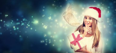 Happy young woman holding a present box clipart