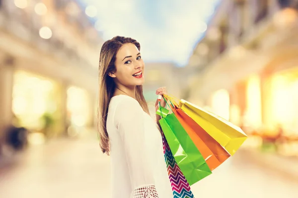 Szczęśliwa młoda kobieta trzyma torby na zakupy — Zdjęcie stockowe