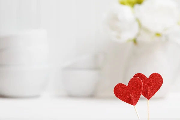 Små röda hjärtan med vita porslin rätter — Stockfoto
