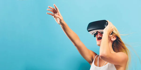 Jovem mulher usando fone de ouvido realidade virtual — Fotografia de Stock