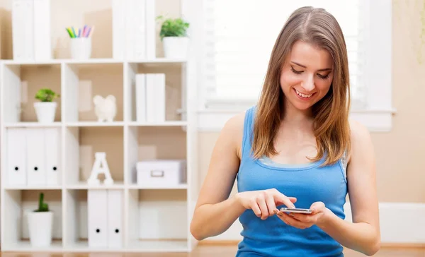 Gelukkig jonge vrouw met behulp van haar mobiel — Stockfoto