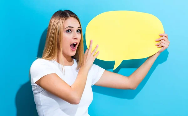 Mujer joven sosteniendo una burbuja del discurso —  Fotos de Stock