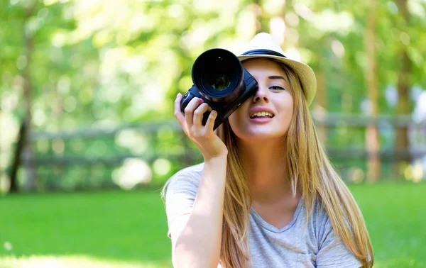 Vrouwelijke fotograaf met een camera buiten — Stockfoto