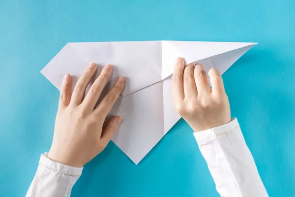 Hände falten ein Papierflugzeug — Stockfoto