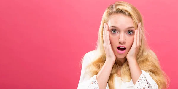 Verrast jonge vrouw op een lichte achtergrond — Stockfoto