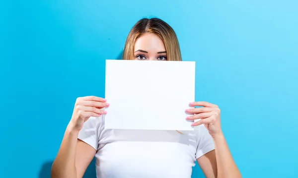 Mujer sosteniendo una hoja de papel en blanco — Foto de Stock