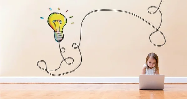 Light Bulb with little girl using a laptop computer — Stock Photo, Image