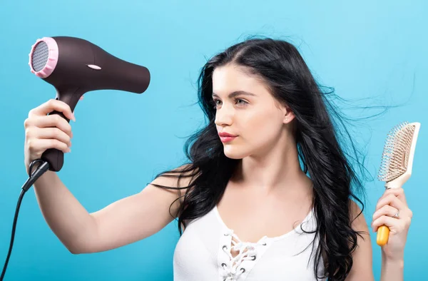 Mulher bonita segurando um secador de cabelo — Fotografia de Stock