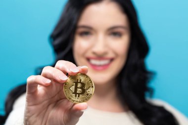 Fiziksel bir bitcoin tutan kadın