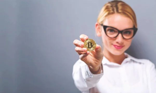 Fiziksel bir bitcoin tutan kadın — Stok fotoğraf