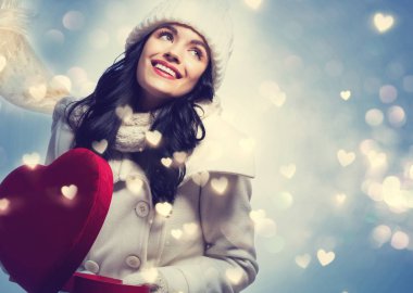 Bir büyük kalp hediye kutusu tutan genç kadın