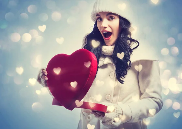 Mujer joven sosteniendo una gran caja de regalo de corazón — Foto de Stock
