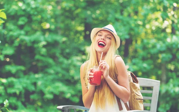 Junge Frau trinkt draußen einen Smoothie — Stockfoto